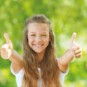 Ein Mädchen streckt ihre Arme und zeigt zwei Daumen nach oben.