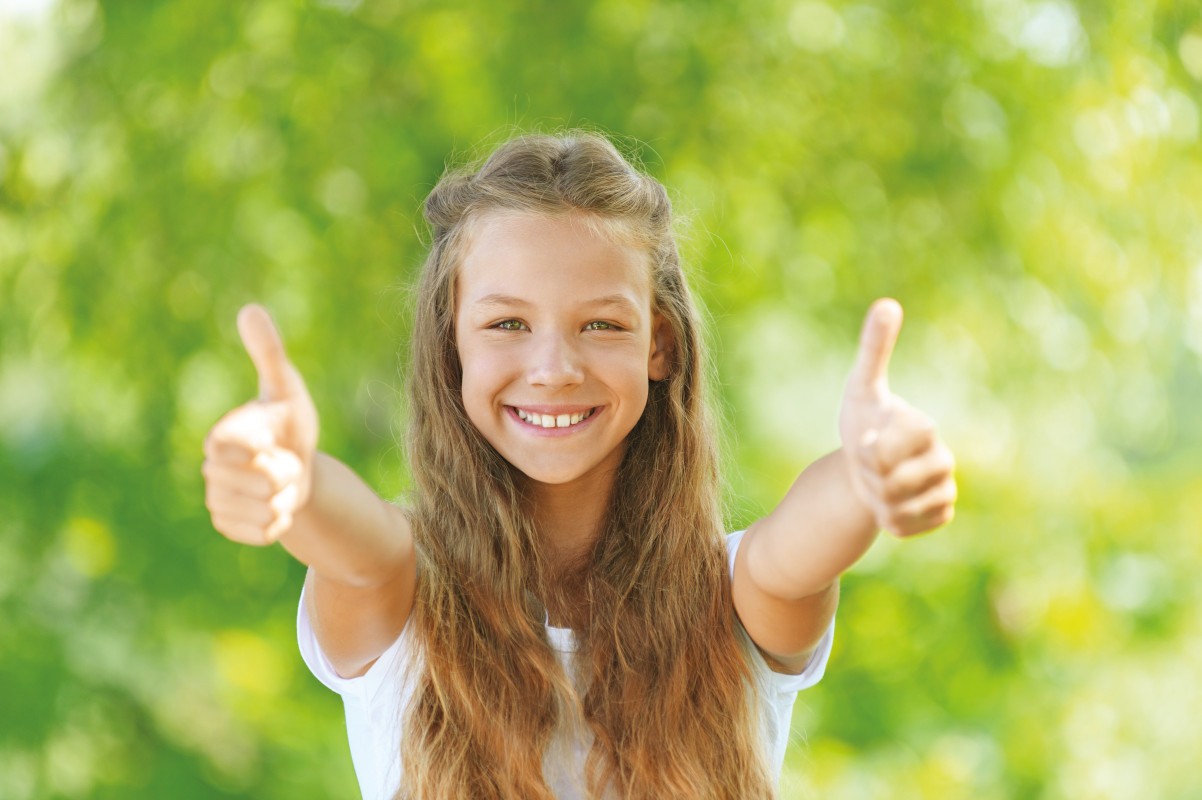 Ein Mädchen streckt ihre Arme und zeigt zwei Daumen nach oben.